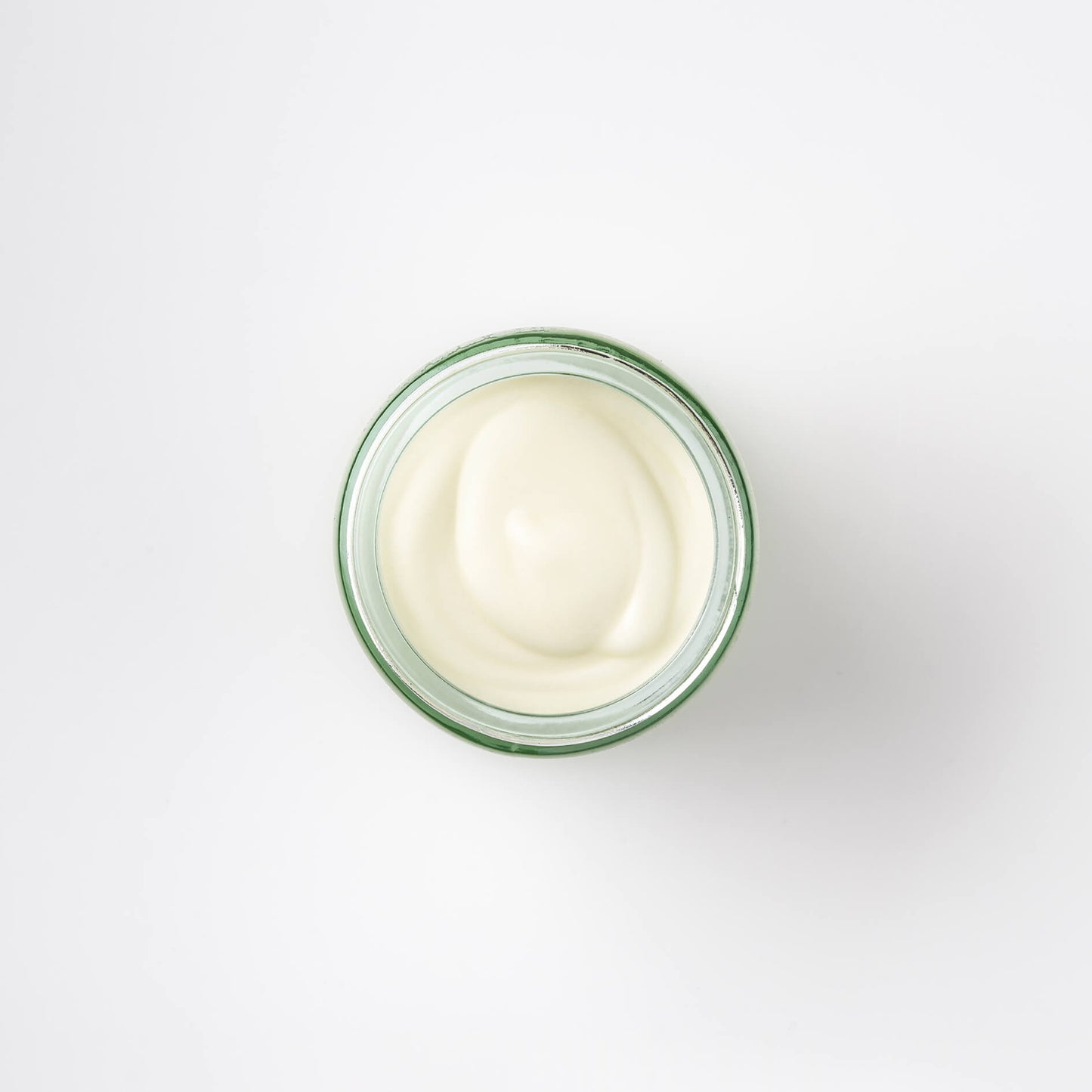 view of the top of a Bristolmade body balm, showing the glossy cream colour of the product and it smooth, silky texture. 