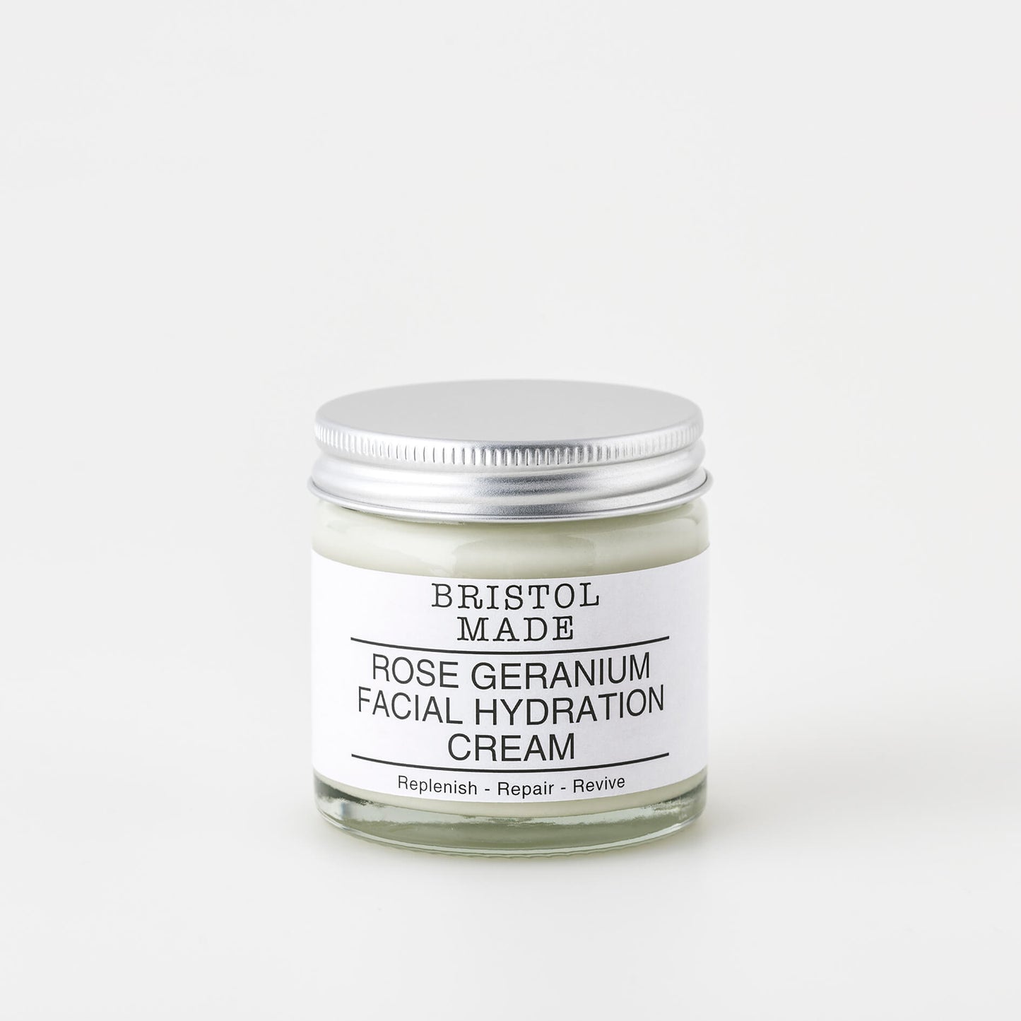 Image of a Bristolmade face cream, in a 60 ml clear glass jar. showing the off white product, a white label with black text, detailing the natural ingredients and how to use the product.