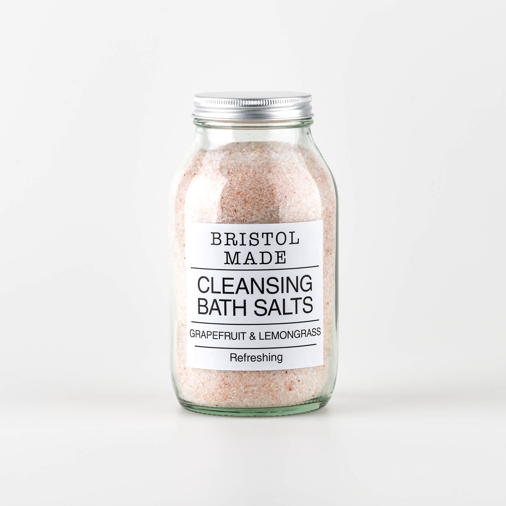 A 500ml clear glass jar of Bristolmade Cleansing, pale pink bath salts, showing a white label with black text.