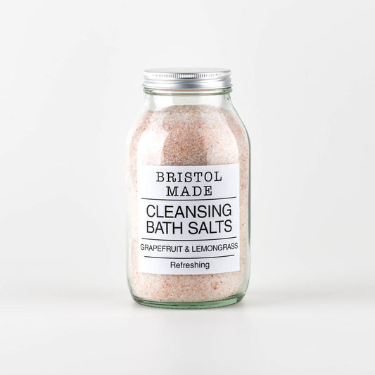 A 500ml clear glass jar of Bristolmade Cleansing Bath Salts, a mix of Epsom and sea salts, combined with essential oils and botanicals for a luxurious bath experience.