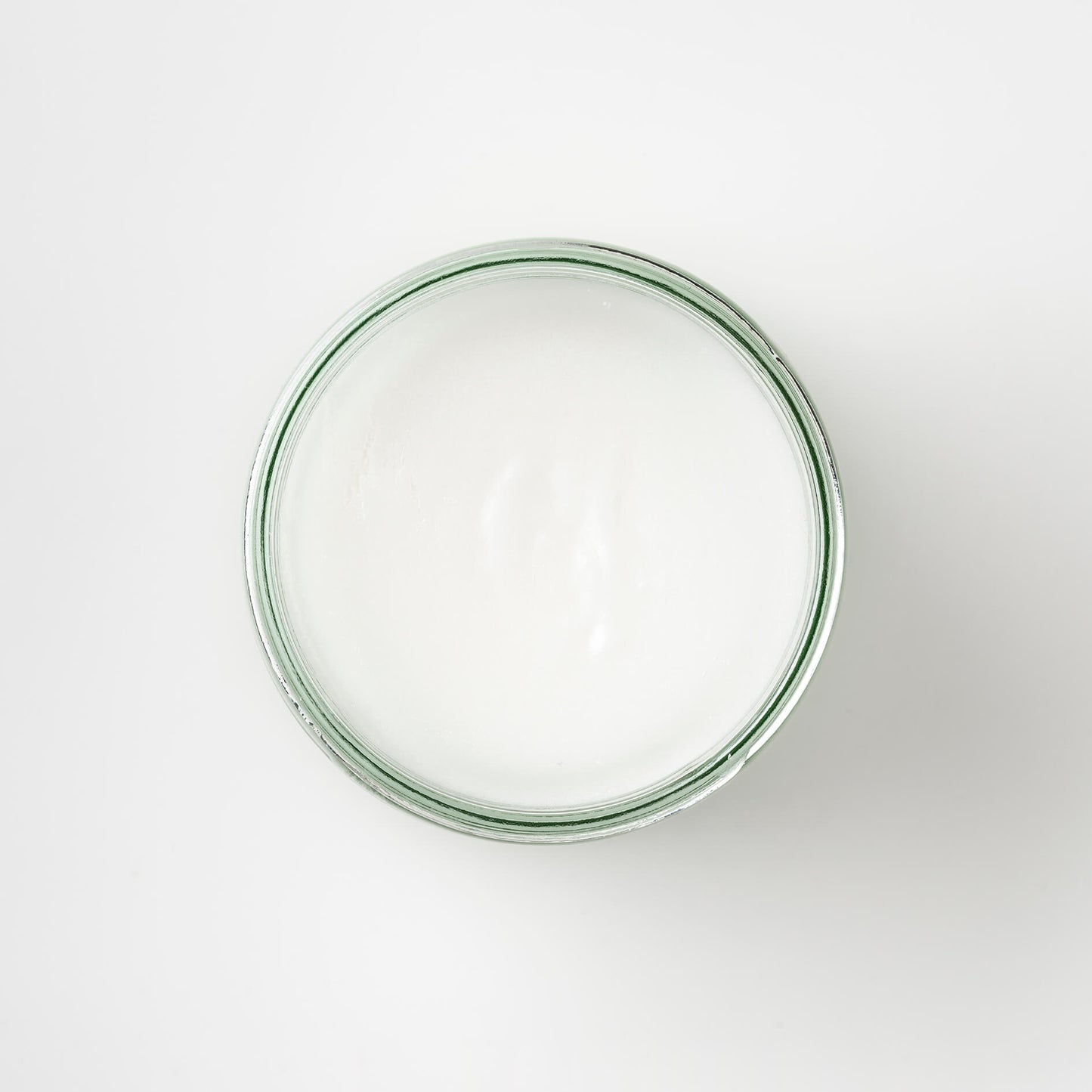 top view of a Bristolmade body scrub, showing the white of the natural ingredients and sugar. In a 250ml sustainable glass jar.