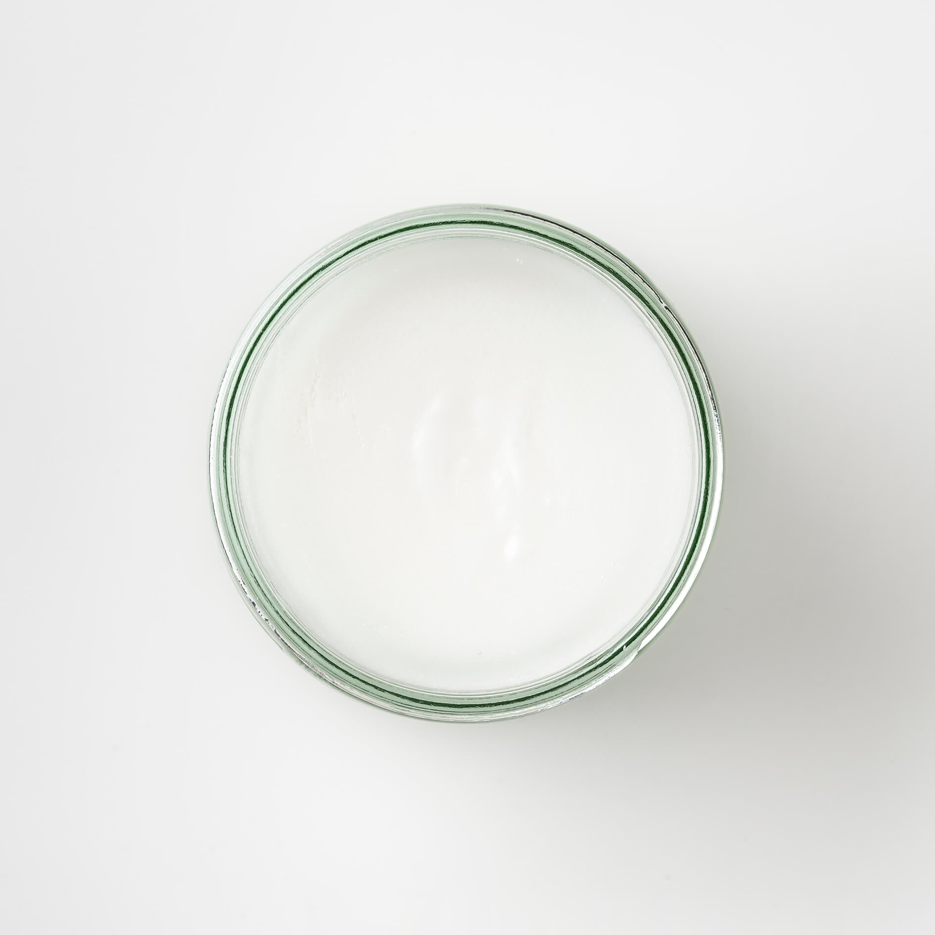 top view of a Bristolmade body scrub, showing the white of the natural ingredients and sugar. In a 250ml sustainable glass jar.