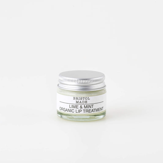 image of a lime and mint Bristolmade lip balm, in a 15ml eco friendly clear glass jar. Showing a white label with black text and the off white product.